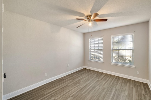 empty room with ceiling fan and hardwood / wood-style flooring