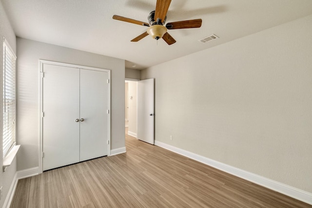 unfurnished bedroom featuring ceiling fan, light hardwood / wood-style floors, and a closet