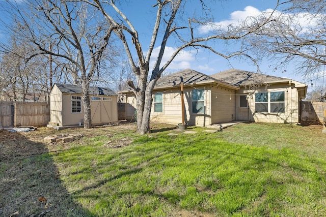 back of house featuring a yard and a storage shed