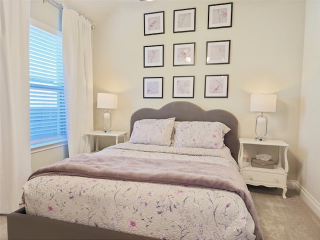 bedroom with carpet floors and vaulted ceiling