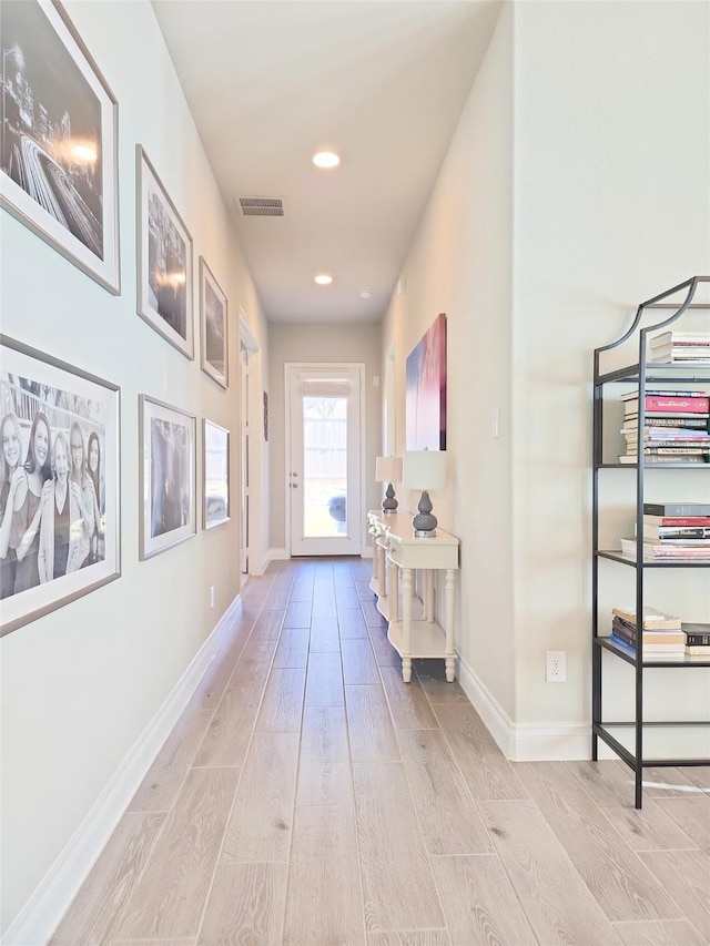 corridor with light hardwood / wood-style flooring