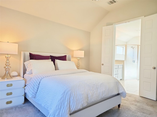 carpeted bedroom with ensuite bathroom and vaulted ceiling