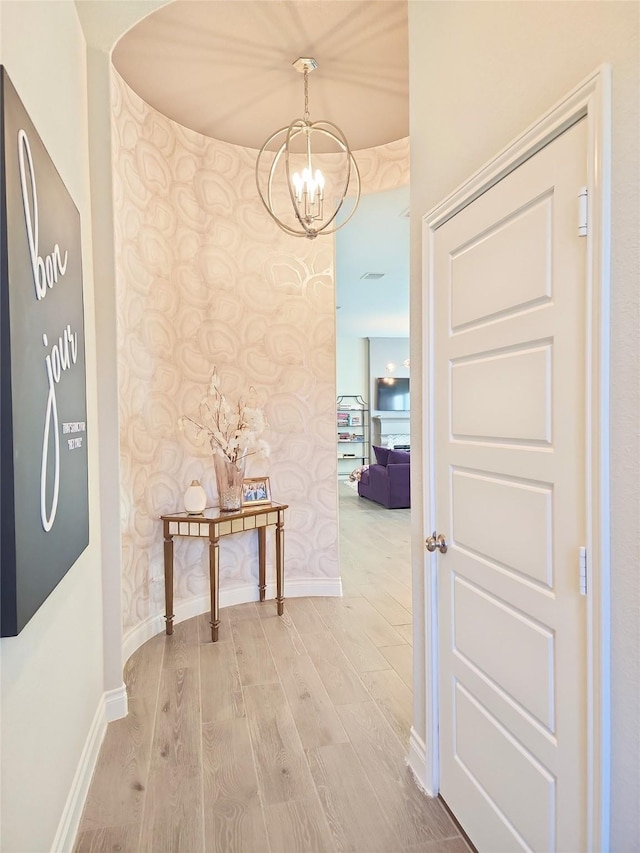 hallway with a notable chandelier and wood-type flooring