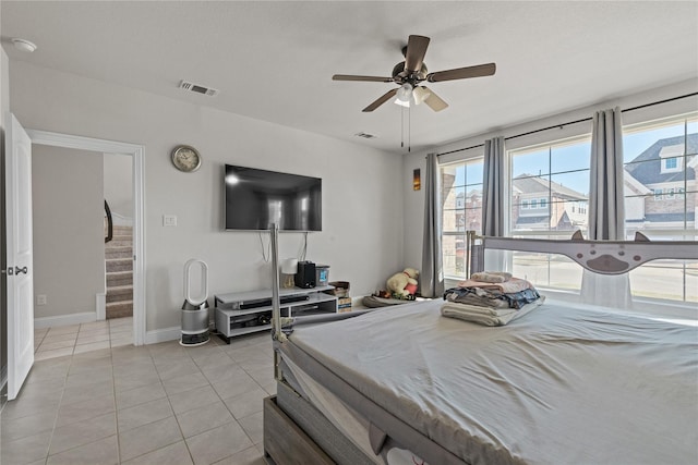 bedroom with multiple windows, light tile patterned floors, and ceiling fan