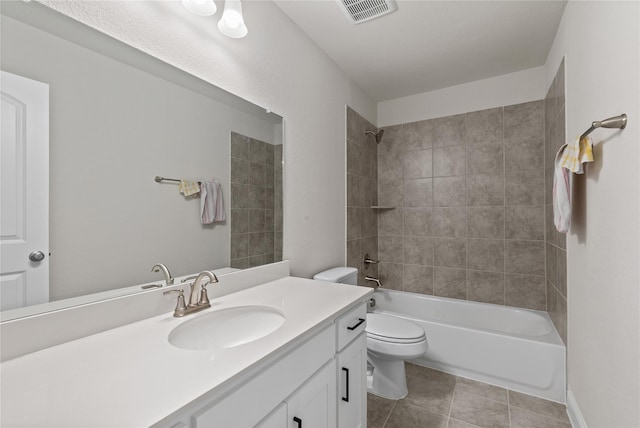 full bathroom with vanity, tiled shower / bath combo, tile patterned floors, and toilet