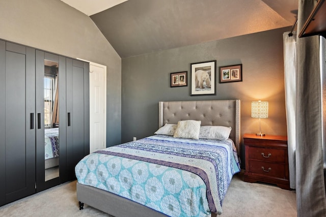 bedroom featuring lofted ceiling, light colored carpet, and a closet