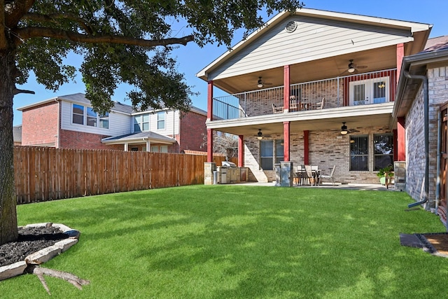 back of house featuring a patio, a balcony, a yard, and ceiling fan