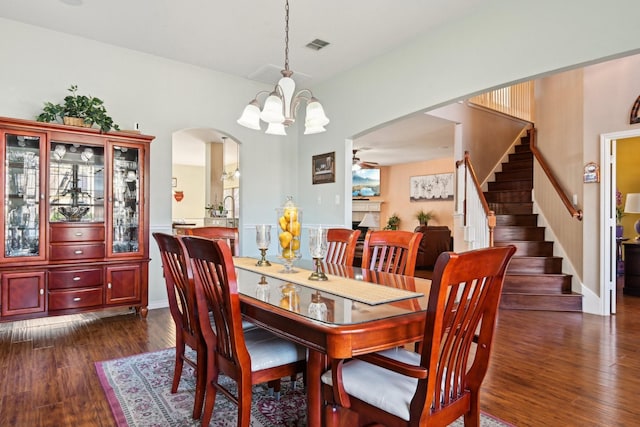 dining area with dark hardwood / wood-style floors and an inviting chandelier