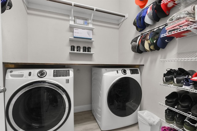 clothes washing area with light wood-type flooring and washing machine and clothes dryer