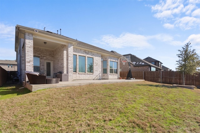 rear view of house featuring a lawn and a patio