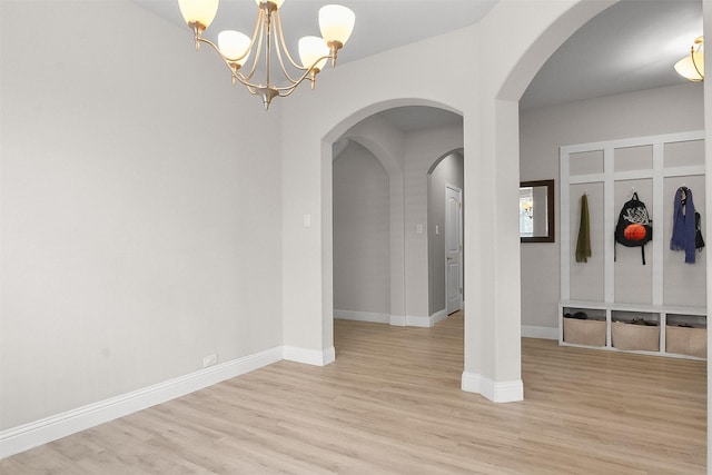 mudroom with an inviting chandelier and light hardwood / wood-style floors