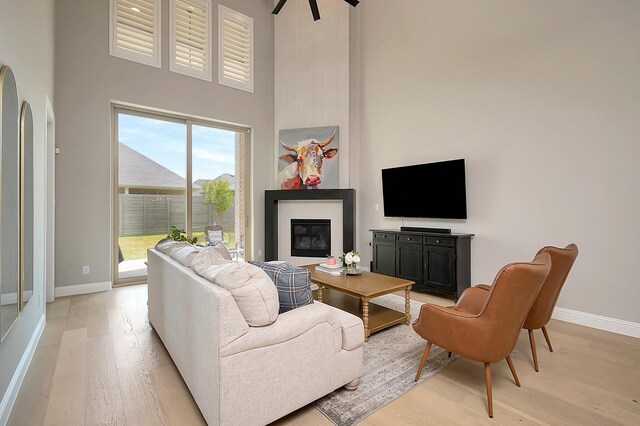 living room featuring a towering ceiling and light hardwood / wood-style floors