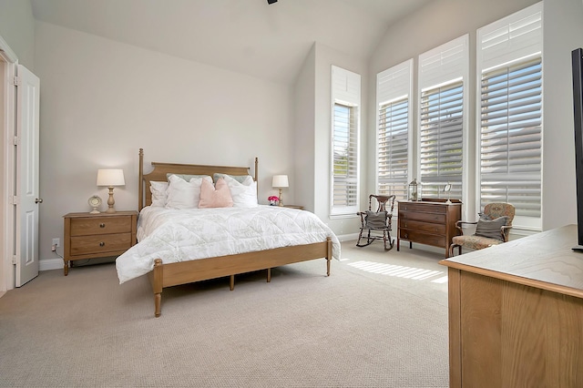 bedroom with light colored carpet and lofted ceiling