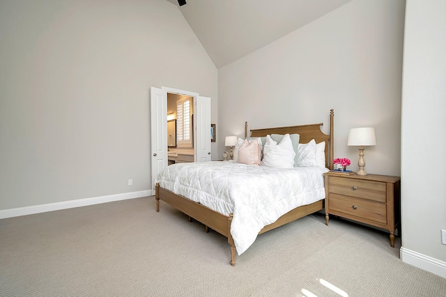 bedroom featuring high vaulted ceiling, light colored carpet, and connected bathroom