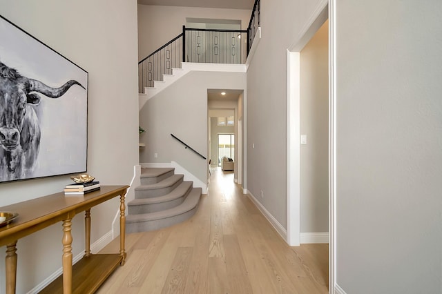 foyer entrance featuring a high ceiling and light hardwood / wood-style floors