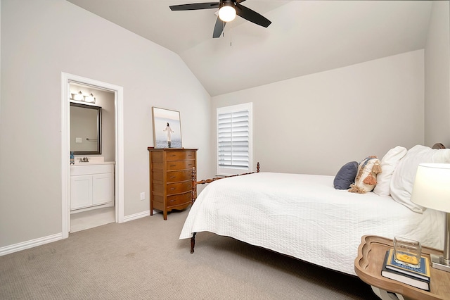 bedroom with ceiling fan, vaulted ceiling, light carpet, and ensuite bath