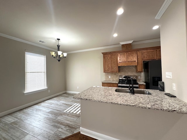 kitchen featuring kitchen peninsula, black fridge with ice dispenser, sink, a chandelier, and light hardwood / wood-style floors