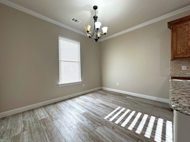 unfurnished dining area featuring light hardwood / wood-style flooring, ornamental molding, and a notable chandelier