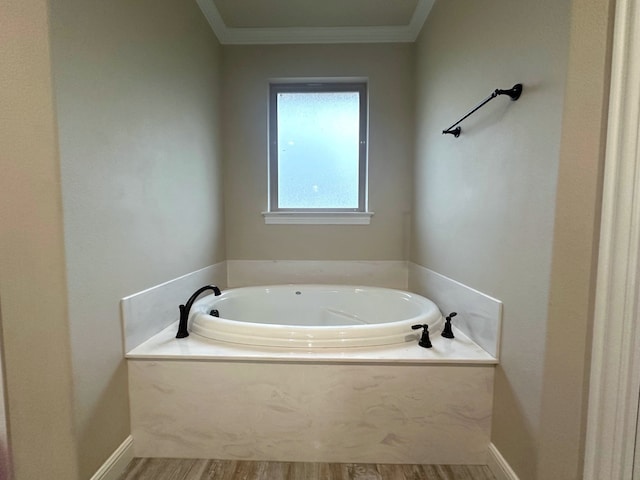 bathroom with hardwood / wood-style floors, crown molding, and a tub