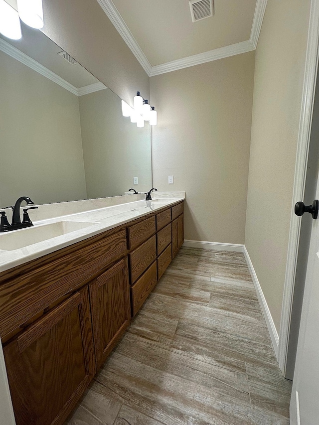 bathroom with hardwood / wood-style floors, vanity, and crown molding