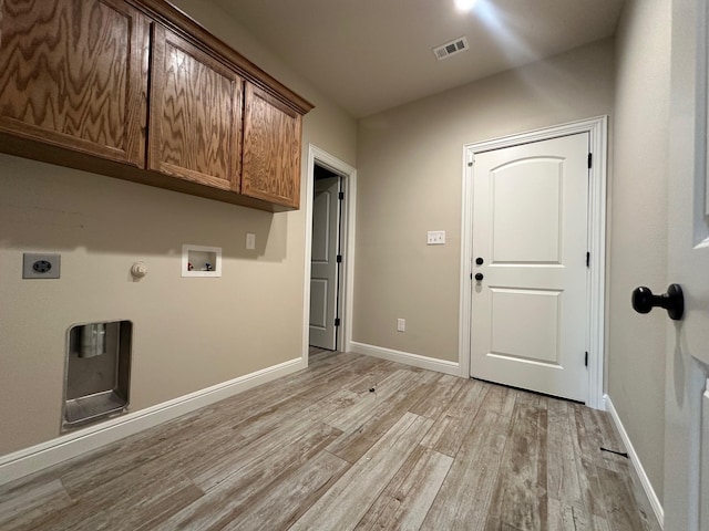 laundry area with electric dryer hookup, cabinets, gas dryer hookup, washer hookup, and light wood-type flooring