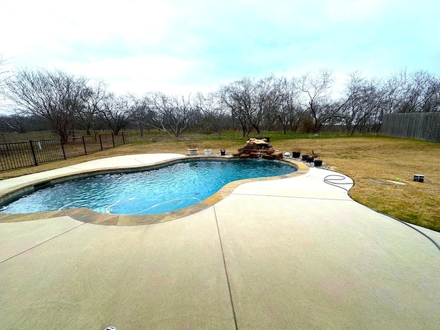 view of swimming pool featuring pool water feature, a yard, and a patio