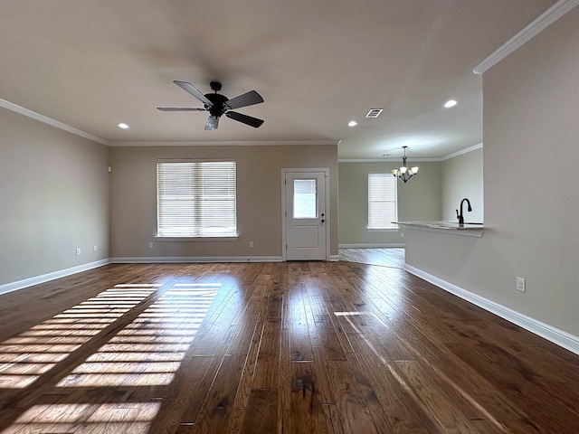 unfurnished living room with ceiling fan with notable chandelier, dark hardwood / wood-style floors, ornamental molding, and sink