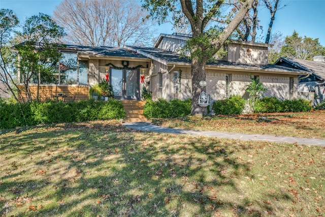 view of front of property with brick siding and a front lawn