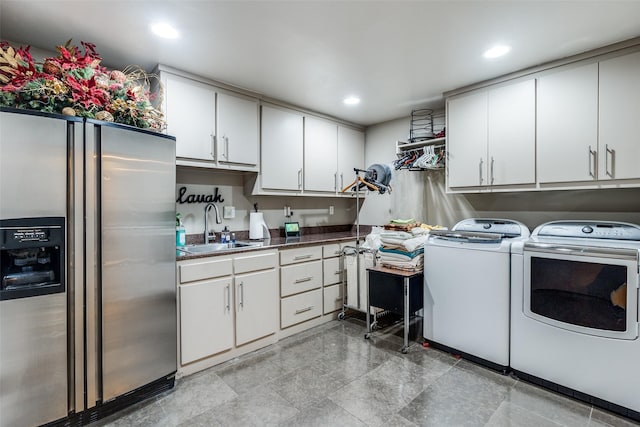 laundry area featuring cabinets, washer and clothes dryer, and sink