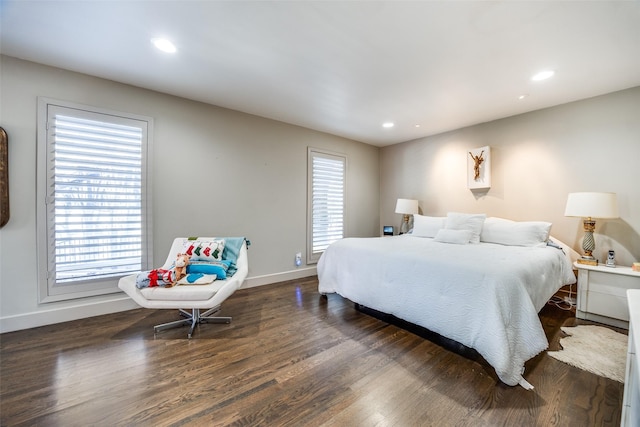 bedroom with multiple windows and dark hardwood / wood-style flooring