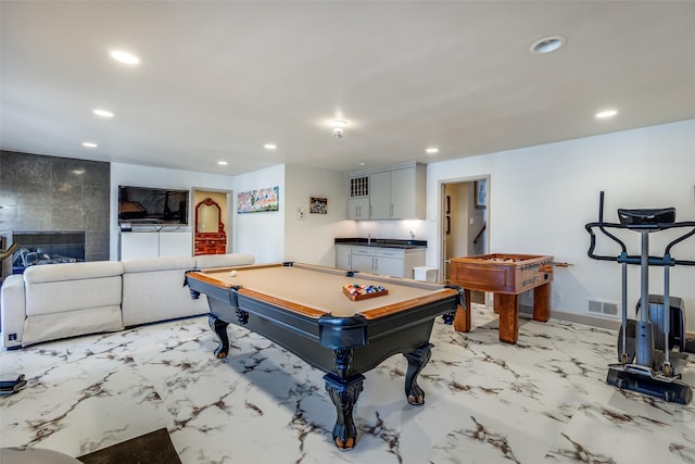 recreation room with a fireplace and pool table