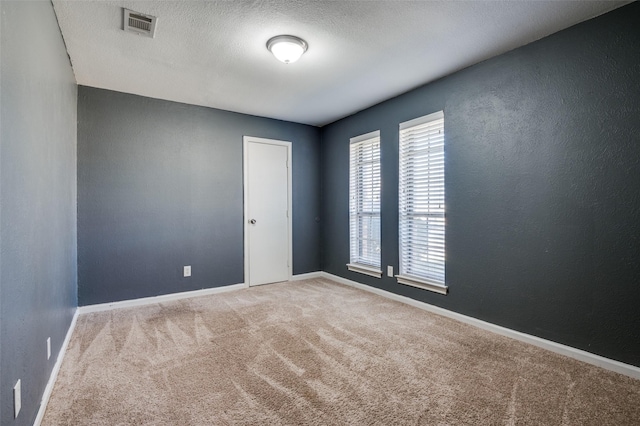 carpeted spare room with a textured ceiling