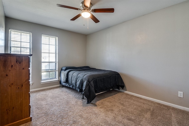 carpeted bedroom featuring multiple windows and ceiling fan