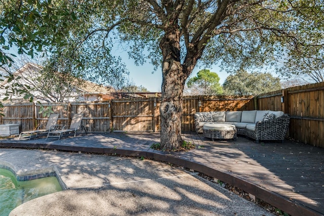 rear view of property featuring an outdoor living space, a deck, and a patio area