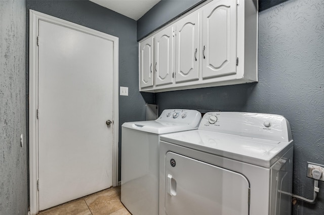 clothes washing area with cabinets, light tile patterned floors, and separate washer and dryer