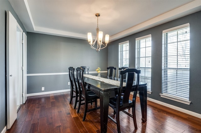 dining room with dark hardwood / wood-style flooring and an inviting chandelier