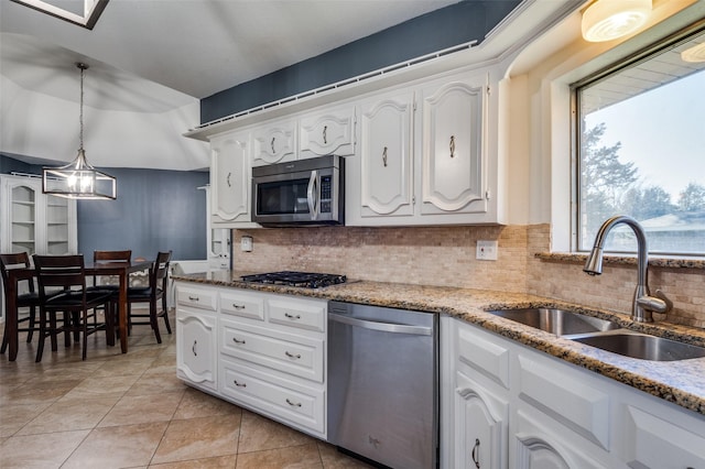 kitchen with pendant lighting, white cabinetry, sink, and stainless steel appliances