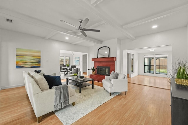 living room with beam ceiling, ceiling fan, plenty of natural light, and light hardwood / wood-style flooring