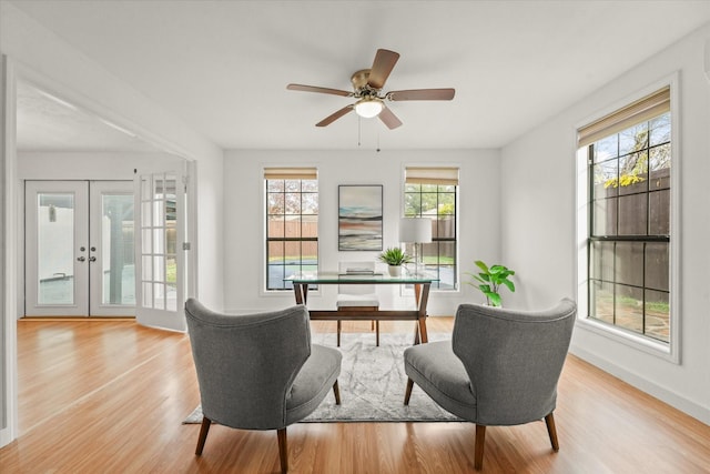 interior space with light wood finished floors, ceiling fan, baseboards, and french doors