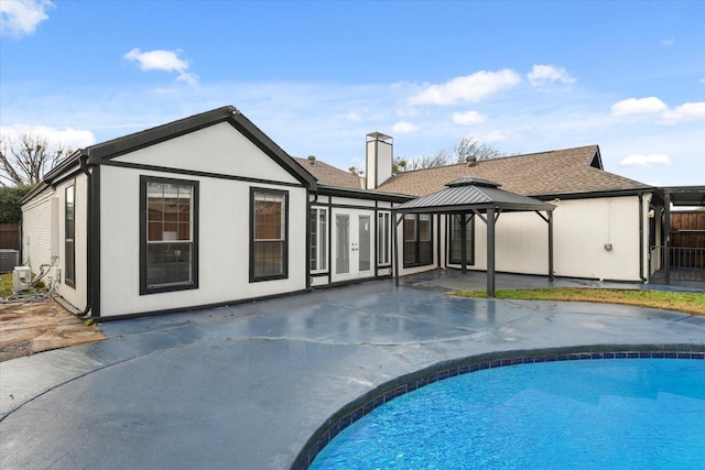 back of house with a gazebo, a patio area, and a fenced in pool