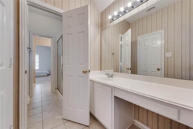 bathroom featuring walk in shower, vanity, and tile patterned flooring