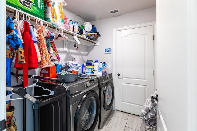 clothes washing area with separate washer and dryer and light tile patterned floors