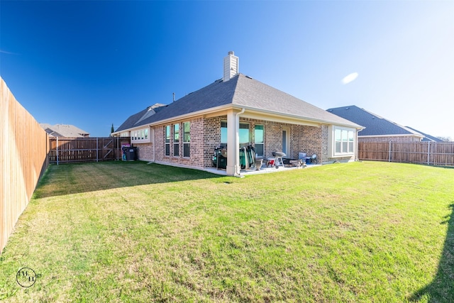 rear view of house with a patio area and a lawn