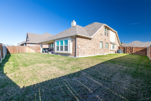 rear view of house with a yard and central air condition unit