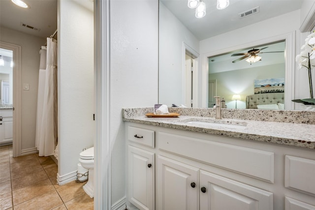 bathroom with tile patterned floors, vanity, toilet, and ceiling fan