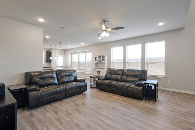 living room with light wood-type flooring and ceiling fan