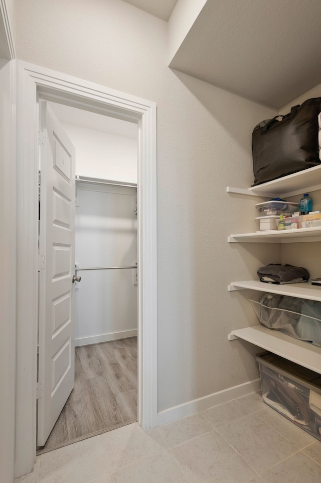 spacious closet with light tile patterned floors