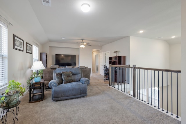 living room with ceiling fan, light colored carpet, and lofted ceiling