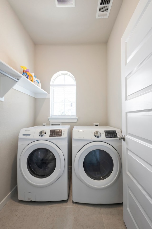 laundry room with light tile patterned floors and separate washer and dryer