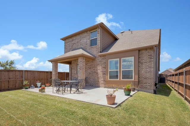 back of house featuring a lawn and a patio area